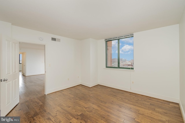 spare room featuring wood-type flooring