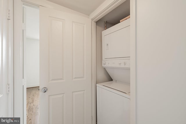 washroom featuring stacked washer / drying machine and wood-type flooring