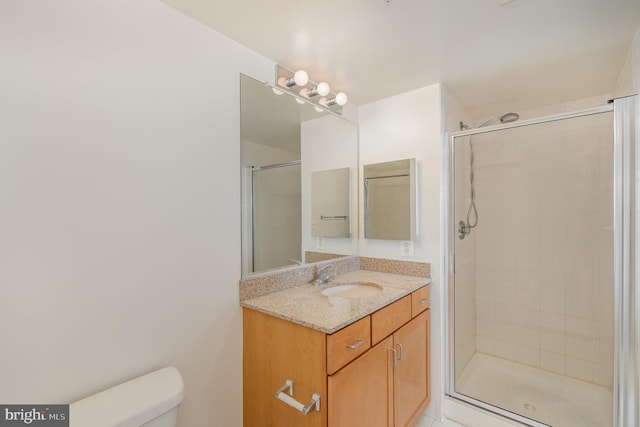 bathroom with an enclosed shower, large vanity, and toilet