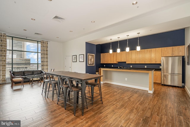 dining area featuring sink, expansive windows, and hardwood / wood-style flooring