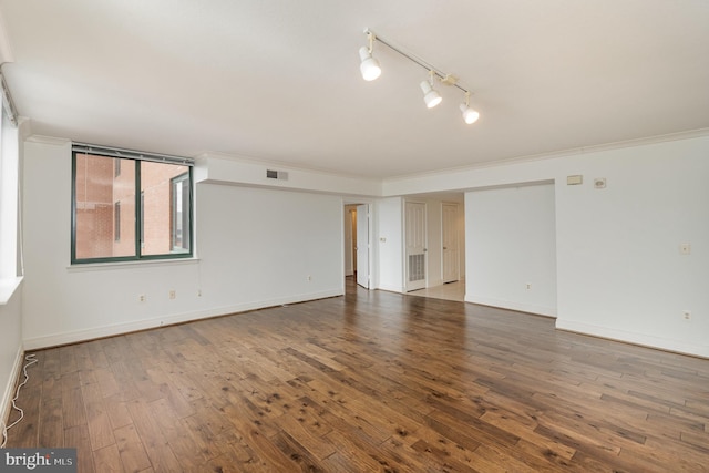 spare room with crown molding, rail lighting, and hardwood / wood-style floors