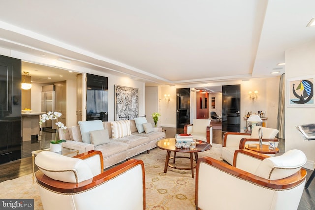 living room featuring a tray ceiling and light wood-type flooring