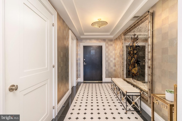 doorway to outside featuring dark tile floors, a raised ceiling, and tile walls