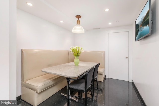 dining area featuring dark tile flooring