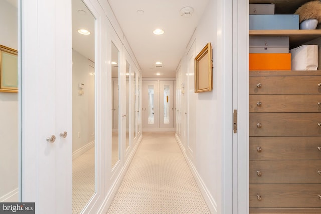 corridor with french doors and light carpet