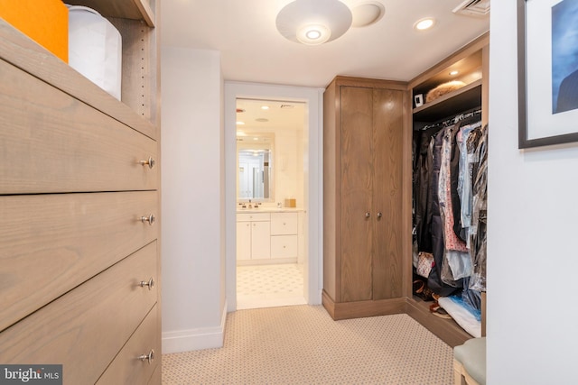 walk in closet featuring light tile floors and sink