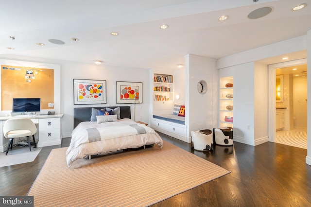 bedroom featuring ensuite bathroom and dark hardwood / wood-style floors