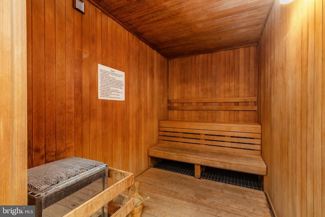 view of sauna / steam room featuring wood walls, wood ceiling, and hardwood / wood-style floors