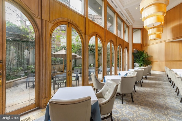 interior space with an inviting chandelier, coffered ceiling, and french doors