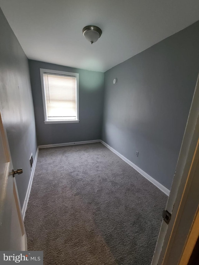 unfurnished room with dark colored carpet