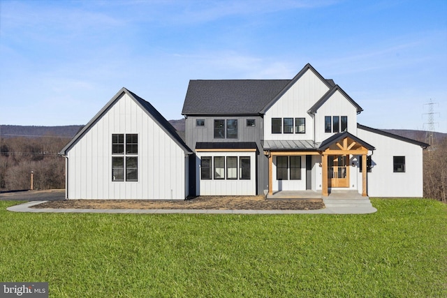 modern farmhouse featuring covered porch and a front lawn