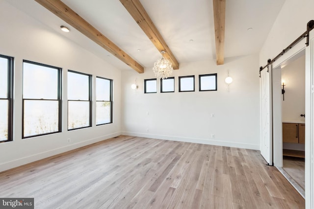 spare room with light wood-type flooring, a barn door, lofted ceiling with beams, and an inviting chandelier