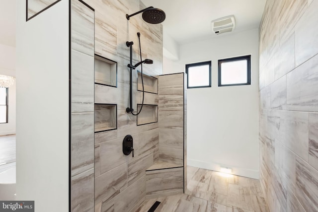 bathroom with a healthy amount of sunlight and tiled shower