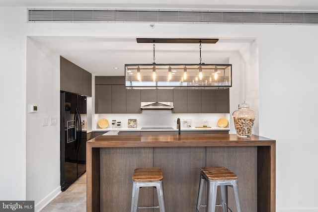 kitchen with a breakfast bar area, kitchen peninsula, hanging light fixtures, and black appliances