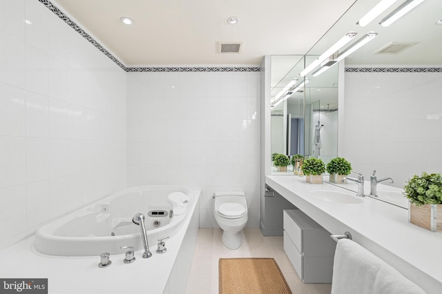 bathroom with vanity, tile walls, tile patterned flooring, toilet, and a tub