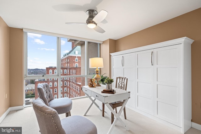 office space featuring ceiling fan, light colored carpet, and a wealth of natural light