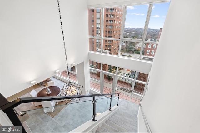 interior space with plenty of natural light, a towering ceiling, and an inviting chandelier