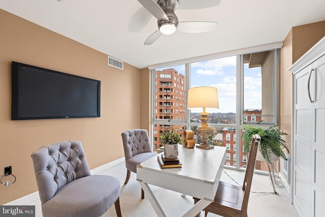 carpeted office featuring ceiling fan and expansive windows