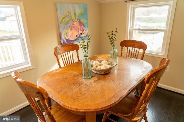 dining area with crown molding, dark hardwood / wood-style flooring, and a healthy amount of sunlight