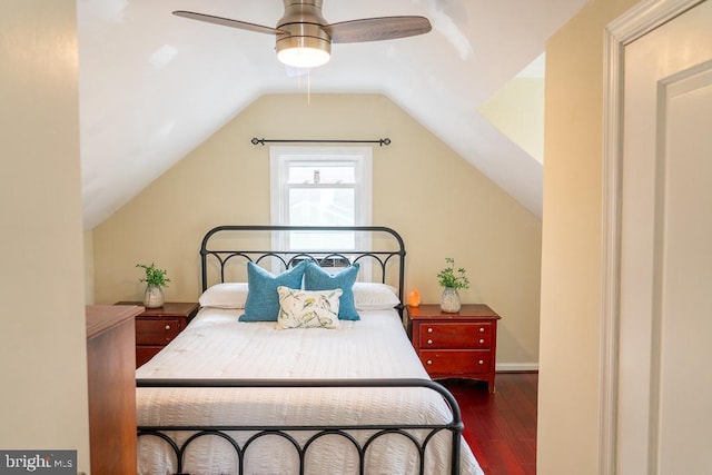 bedroom with ceiling fan, dark wood-type flooring, and vaulted ceiling