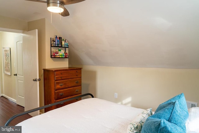 bedroom with ceiling fan, dark wood-type flooring, and vaulted ceiling