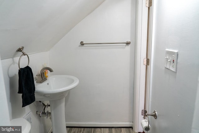 bathroom featuring toilet, vaulted ceiling, and hardwood / wood-style flooring