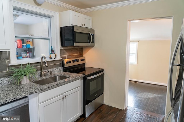 kitchen with sink, stainless steel appliances, light stone counters, decorative backsplash, and white cabinets