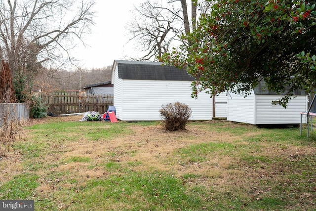 view of yard featuring a storage unit and a trampoline