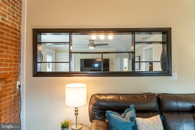 living room with ceiling fan and brick wall