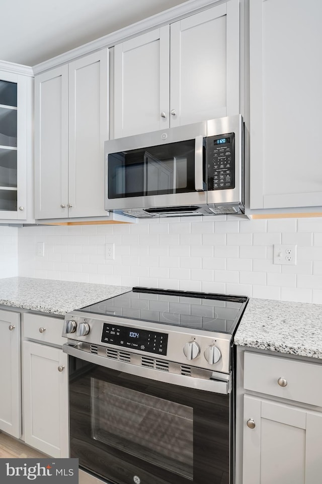 laundry room with separate washer and dryer and light hardwood / wood-style flooring