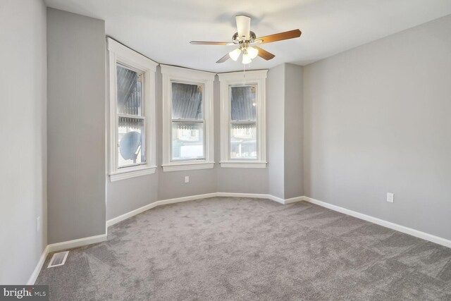 carpeted empty room featuring ceiling fan