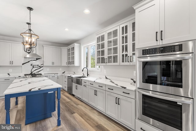 kitchen with white cabinets, light stone countertops, and stainless steel appliances