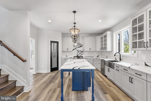 kitchen featuring light hardwood / wood-style floors, a kitchen island, light stone counters, and a breakfast bar area