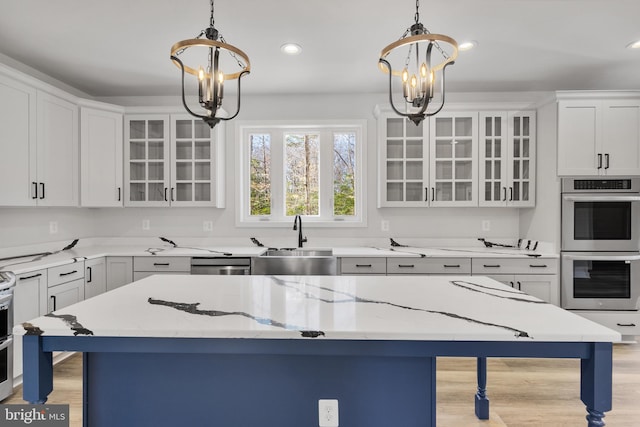 kitchen with white cabinetry, light wood-type flooring, appliances with stainless steel finishes, and sink