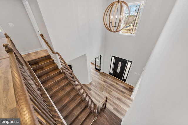 entrance foyer with dark hardwood / wood-style flooring, a chandelier, and a towering ceiling