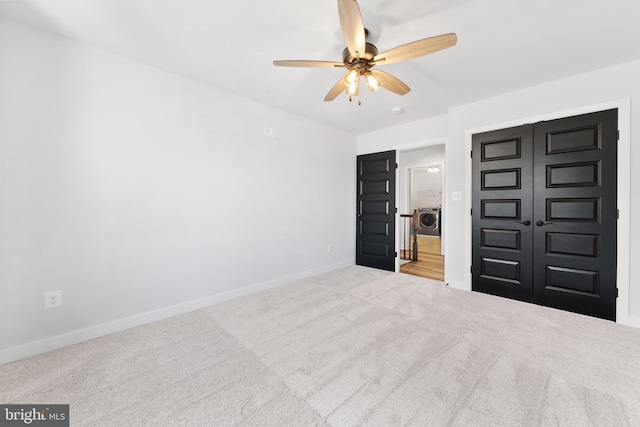 unfurnished bedroom with washer / clothes dryer, ceiling fan, light carpet, and a closet