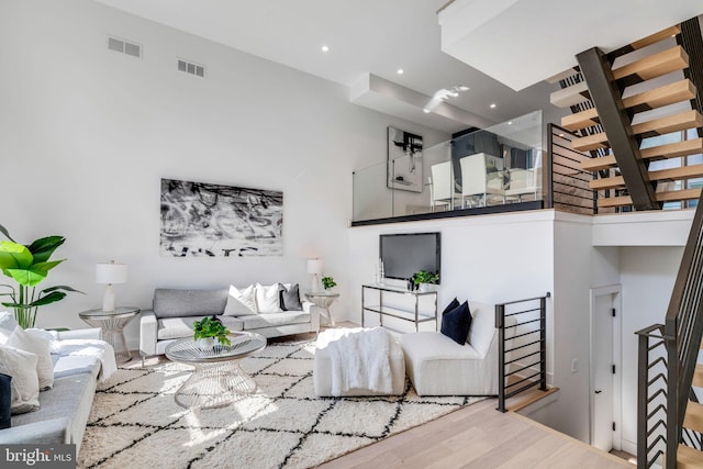 living room with wood-type flooring and a high ceiling