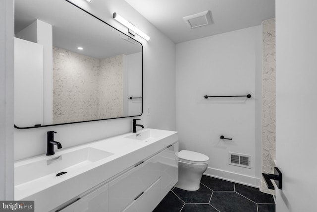 bathroom featuring tile patterned flooring, vanity, and toilet