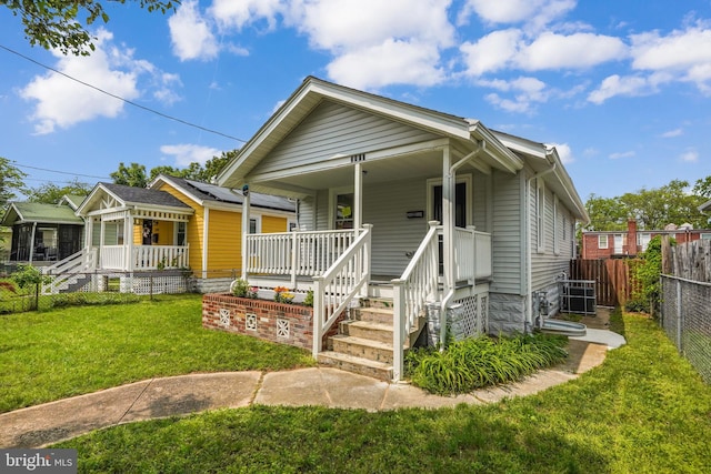 bungalow-style home with covered porch and a front lawn