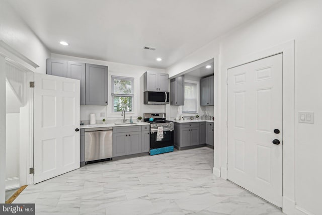 kitchen featuring appliances with stainless steel finishes, sink, and gray cabinetry