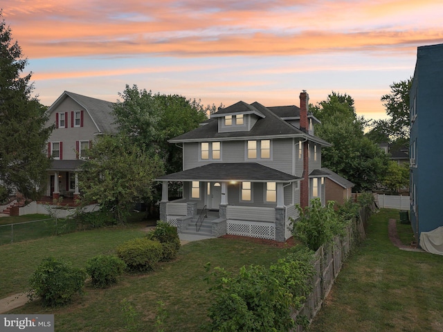 view of front of home with a porch and a yard