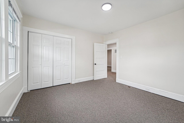 unfurnished bedroom featuring carpet floors and a closet