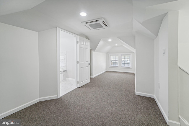 additional living space featuring lofted ceiling and dark carpet