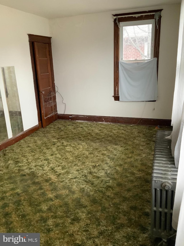 unfurnished room with dark carpet