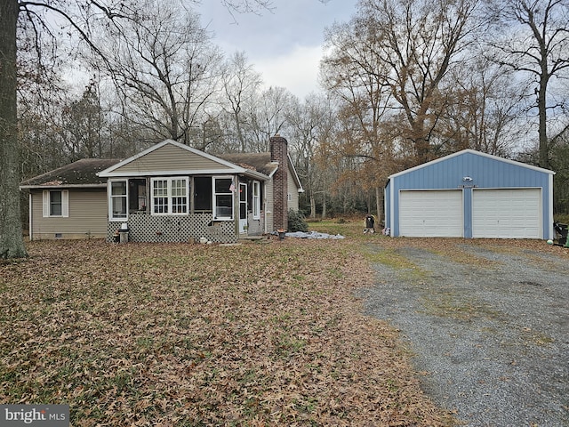 view of front of house with a sunroom, a garage, and an outdoor structure