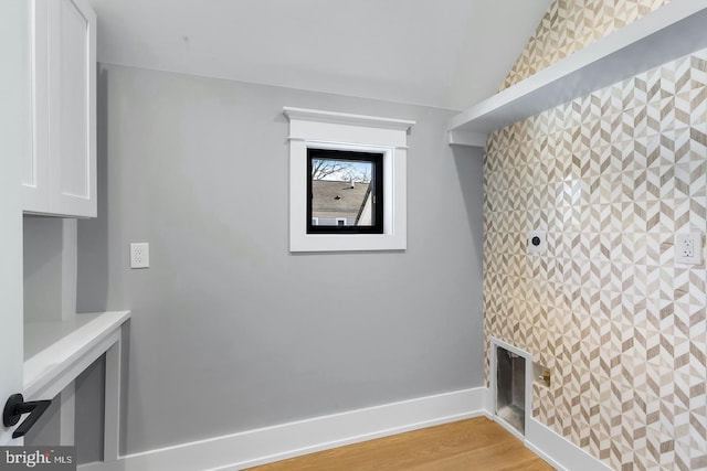 clothes washing area with light hardwood / wood-style flooring