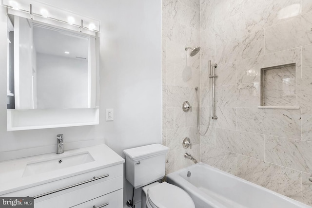 full bathroom with vanity, tiled shower / bath combo, and toilet