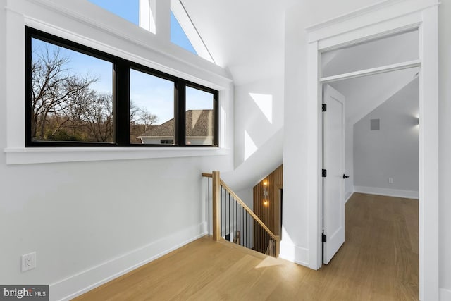 stairway with hardwood / wood-style flooring and lofted ceiling