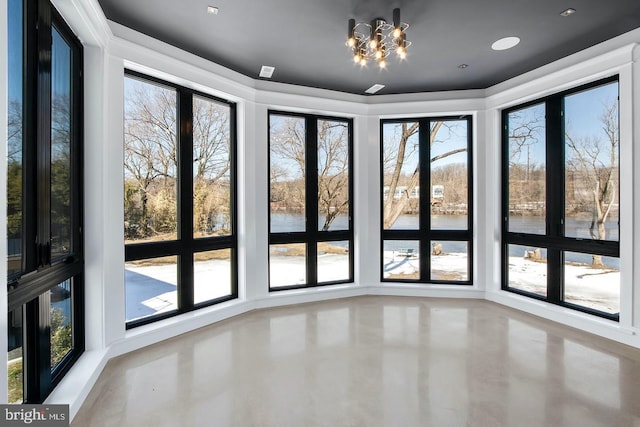 interior space with a wealth of natural light, a water view, and an inviting chandelier