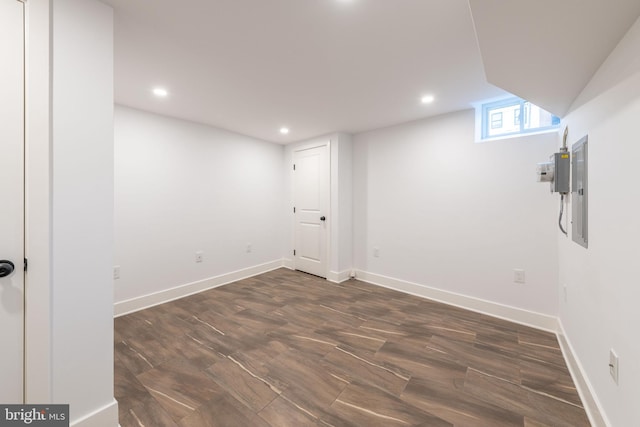 basement with dark hardwood / wood-style flooring and electric panel